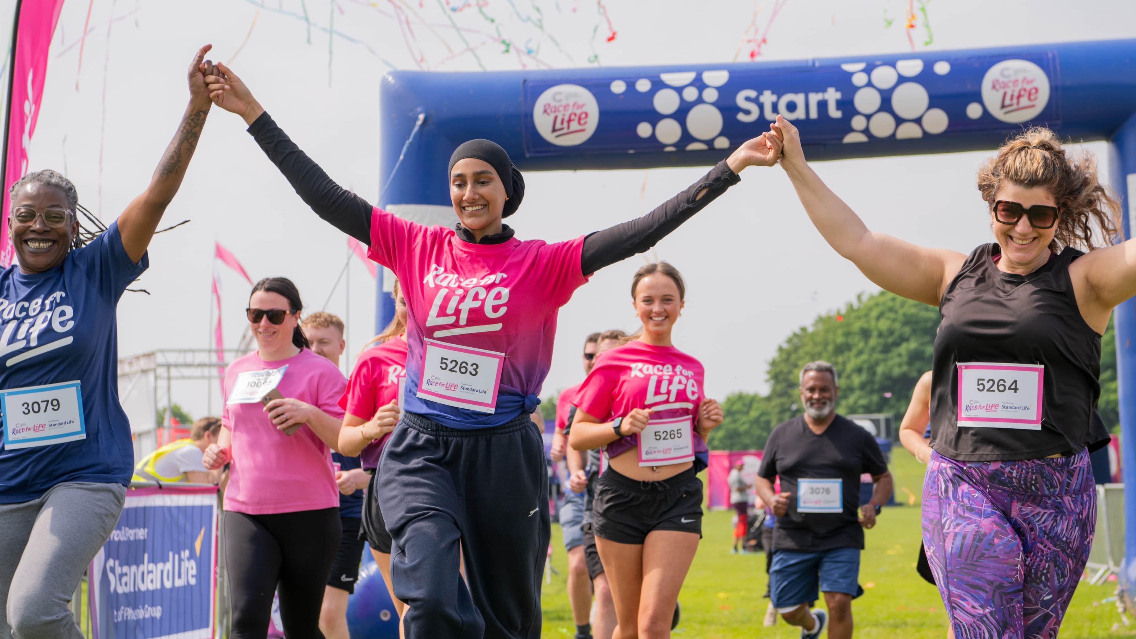 A group of people celebrating as they cross the finish line.