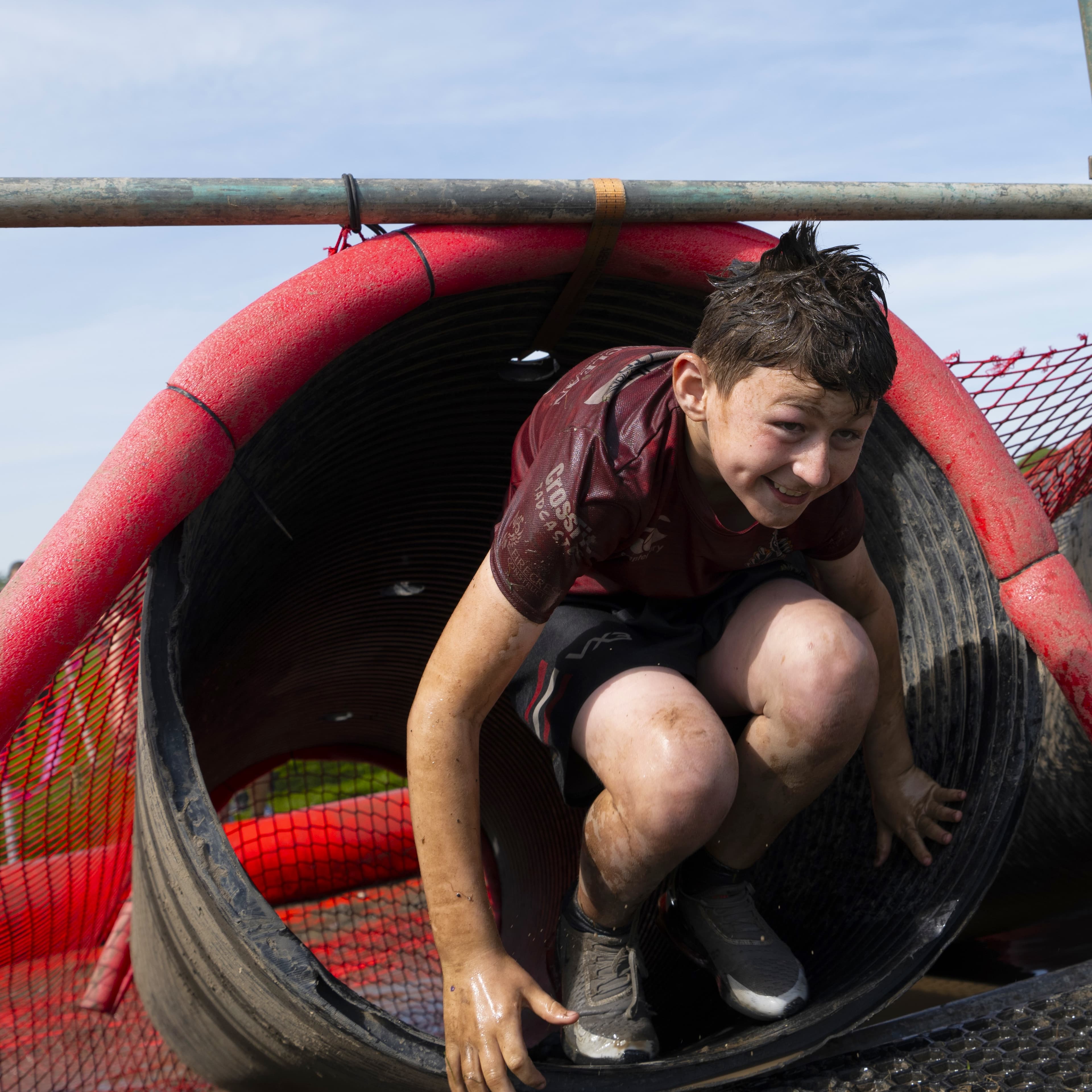 Pretty Muddy supporter crawling in tunnel.