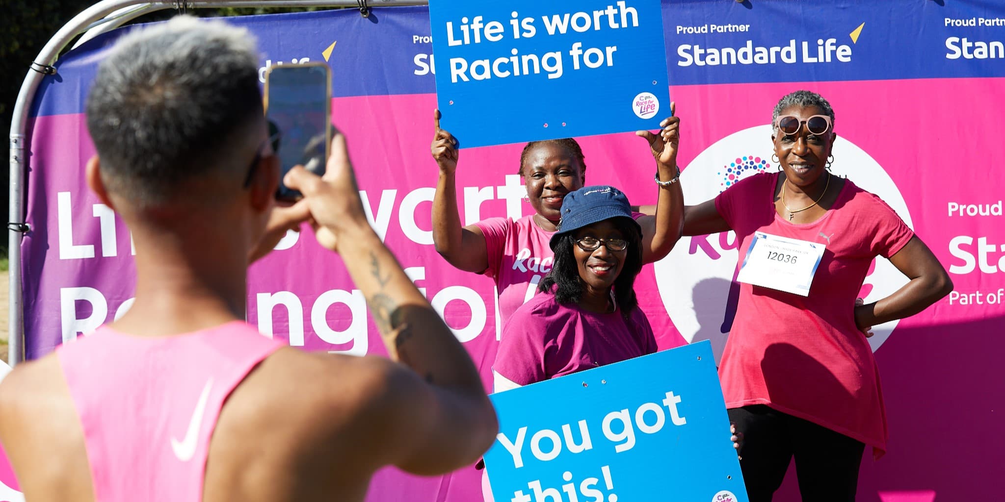Group of three women getting there picture taken by another participant.